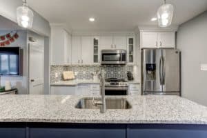 view of sink refrigerator and countertops of brand new modern classy kitchen