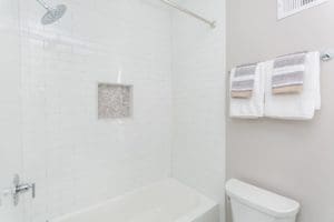 Bathtub in hall bathroom showcasing new tile